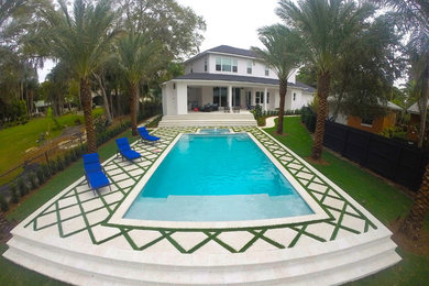 Mid-sized tropical courtyard pool in Orlando with a water feature and concrete pavers.