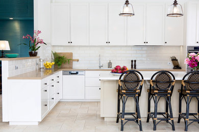 Photo of a mid-sized transitional kitchen in Brisbane with a drop-in sink, shaker cabinets, white cabinets, white splashback, subway tile splashback, panelled appliances, with island, beige floor and beige benchtop.