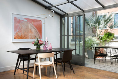 Inspiration for a contemporary open plan dining in Sydney with white walls and brown floor.