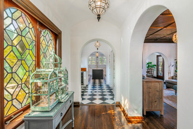 Inspiration for a mid-sized mediterranean medium tone wood floor, red floor and wood ceiling hallway remodel in Los Angeles with white walls