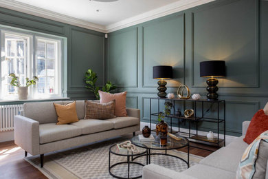 This is an example of a medium sized classic formal enclosed living room in Other with green walls, medium hardwood flooring, brown floors, panelled walls and a dado rail.