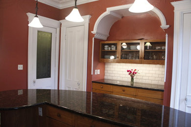 Elegant kitchen photo in New York with granite countertops, white backsplash, subway tile backsplash, stainless steel appliances and an island
