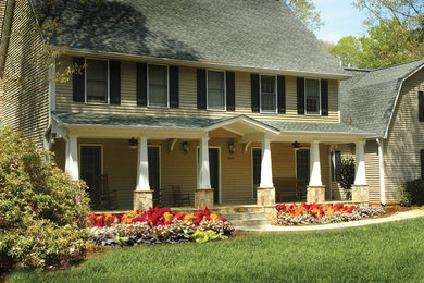 Inspiration for a large traditional front yard verandah in Atlanta with natural stone pavers and a roof extension.