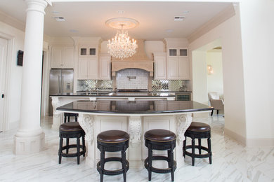 Example of a huge ornate single-wall ceramic tile open concept kitchen design in New Orleans with a double-bowl sink, white cabinets, granite countertops, metallic backsplash, glass tile backsplash, stainless steel appliances and two islands
