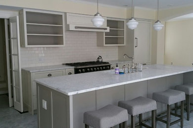 Eat-in kitchen - mid-sized transitional single-wall marble floor and gray floor eat-in kitchen idea in Boston with an undermount sink, shaker cabinets, white cabinets, marble countertops, white backsplash, subway tile backsplash, paneled appliances and an island