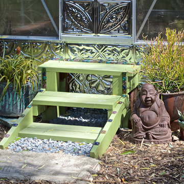 Stylish Backyard Greenhouse Entry With Stamped Metal and Recycled Artisan Glass