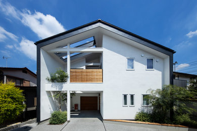 Ejemplo de fachada de casa blanca y negra de tamaño medio de dos plantas con tejado a cuatro aguas y tejado de metal