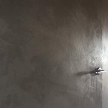 Stucco Moderno su parete con porta a filo muro e cassetti.