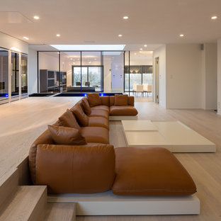 Inspiration for a large contemporary open concept light wood floor home theater remodel in Leipzig with white walls