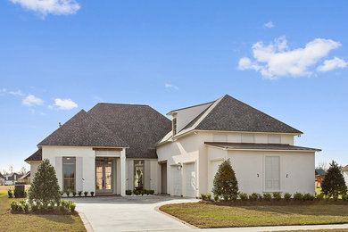 Mid-sized transitional white two-story brick exterior home idea in New Orleans with a hip roof