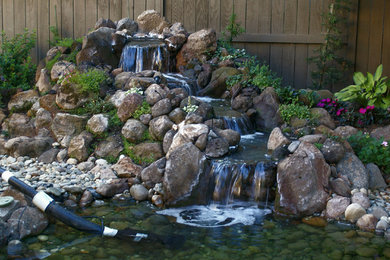 Inspiration for a large rustic backyard water fountain landscape in Sacramento.