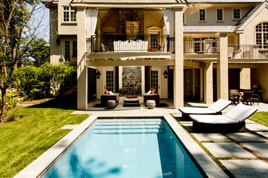 Large transitional backyard rectangular pool in Philadelphia with natural stone pavers.