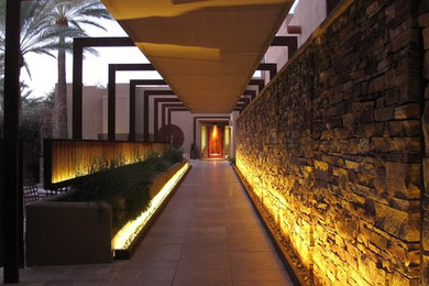 Large trendy travertine floor entryway photo in Phoenix with beige walls and a brown front door