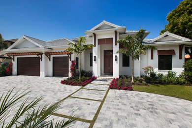 Inspiration for a tropical white one-story stucco house exterior remodel in Miami with a tile roof