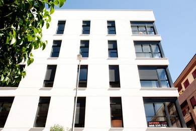 Ejemplo de fachada blanca moderna con revestimiento de aglomerado de cemento y tejado plano