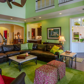 Two-Story Living Room With Leather Sectional, Green Accent Scheme, and Integrate