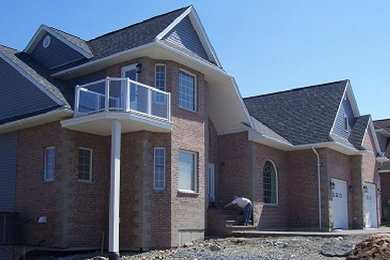 Example of a red two-story brick exterior home design in Other