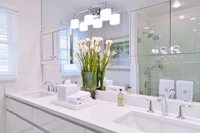 Bathroom - mid-sized contemporary 3/4 white tile and porcelain tile porcelain tile and white floor bathroom idea in New York with flat-panel cabinets, white cabinets, a one-piece toilet, white walls, an undermount sink, quartzite countertops and a hinged shower door