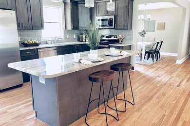 Inspiration for a mid-sized transitional l-shaped light wood floor and multicolored floor eat-in kitchen remodel in Baltimore with an undermount sink, shaker cabinets, gray cabinets, granite countertops, gray backsplash, mosaic tile backsplash, stainless steel appliances, an island and multicolored countertops