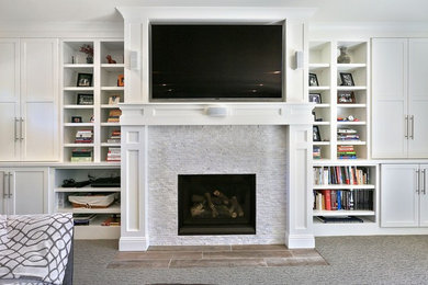 This is an example of a large contemporary open concept living room in San Francisco with grey walls, carpet, a standard fireplace, a wall-mounted tv, grey floor and a stone fireplace surround.