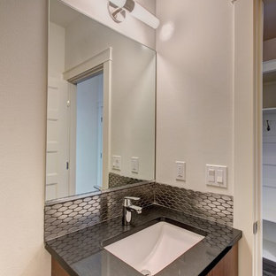 Ispirazione per una piccola stanza da bagno minimalista con ante lisce, ante in legno chiaro, vasca ad alcova, WC a due pezzi, piastrelle nere, piastrelle in metallo, pareti bianche, pavimento in gres porcellanato, lavabo sottopiano, top in quarzo composito e pavimento grigio