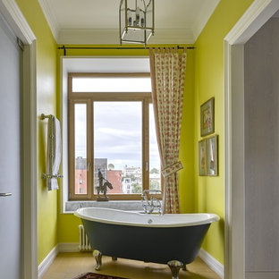 Новые идеи обустройства дома: главная ванная комната в стиле фьюжн с ванной на ножках, желтыми стенами и полом из керамической плитки