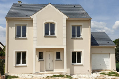 Cette image montre une grande façade de maison de ville blanche design à un étage avec un revêtement mixte, un toit à deux pans et un toit en tuile.
