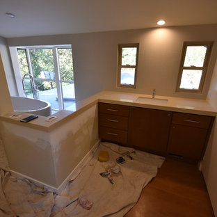 Foto di una grande stanza da bagno padronale minimalista con ante lisce, ante in legno scuro, vasca freestanding, doccia ad angolo, WC monopezzo, piastrelle beige, piastrelle in gres porcellanato, pareti beige, pavimento con piastrelle di ciottoli, lavabo sottopiano, top in rame e pavimento beige