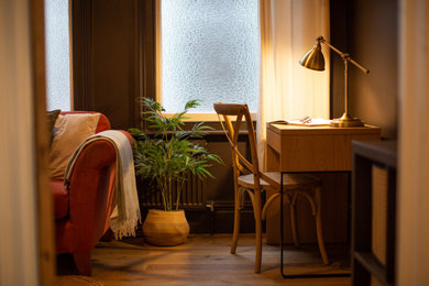 Diseño de despacho tradicional renovado pequeño con paredes marrones, escritorio independiente y suelo marrón