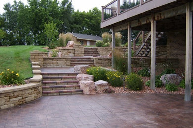 Large elegant backyard stone patio photo in Other with no cover