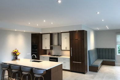 Kitchen - mid-sized modern single-wall concrete floor and gray floor kitchen idea in Calgary with an undermount sink, shaker cabinets, dark wood cabinets, solid surface countertops, beige backsplash, ceramic backsplash, paneled appliances, an island and white countertops