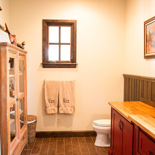Idee per una stanza da bagno con doccia country di medie dimensioni con ante in stile shaker, ante rosse, WC a due pezzi, piastrelle marroni, piastrelle in gres porcellanato, pareti beige, pavimento in gres porcellanato, lavabo sottopiano e top in legno