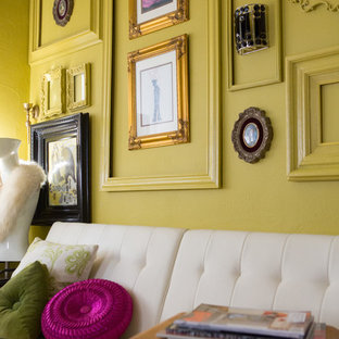 Small modern home office and library in Orlando with yellow walls and a freestanding desk.