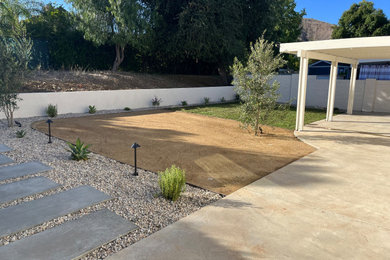 This is an example of a mid-sized traditional desert and full sun decomposed granite landscaping in Los Angeles.