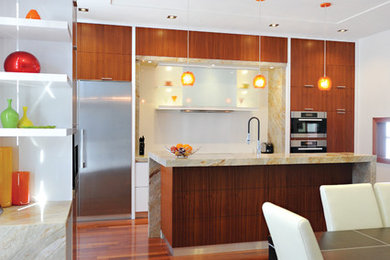 Inspiration for a mid-sized transitional single-wall medium tone wood floor eat-in kitchen remodel in Toronto with a double-bowl sink, flat-panel cabinets, medium tone wood cabinets, granite countertops, multicolored backsplash, stone slab backsplash, stainless steel appliances and an island