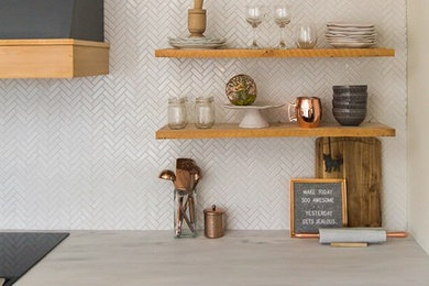 Mid-century modern galley kitchen photo in Birmingham with marble countertops, white backsplash, cement tile backsplash, stainless steel appliances, an island and white countertops