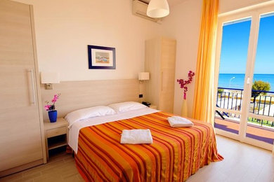Esempio di una camera degli ospiti costiera di medie dimensioni con pareti beige, parquet chiaro e nessun camino