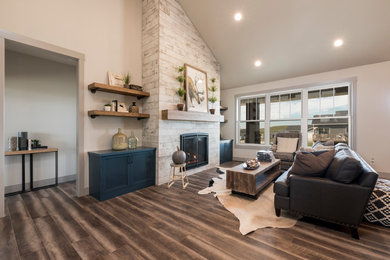 Design ideas for a mid-sized country open concept living room in Other with grey walls, vinyl floors, a standard fireplace, a tile fireplace surround, a concealed tv and brown floor.