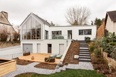 На фото: большой, трехэтажный, деревянный, белый дом в современном стиле с плоской крышей, крышей из смешанных материалов, черной крышей и отделкой планкеном с