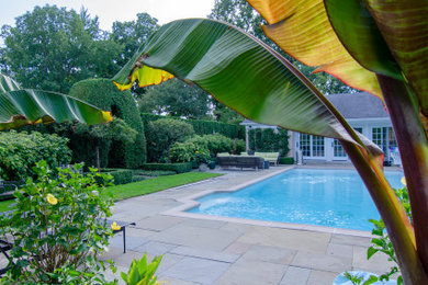 Elegant backyard stone and rectangular pool house photo in Chicago