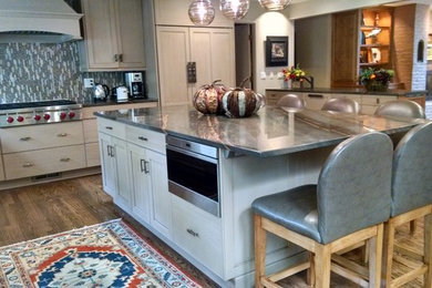 Kitchen - large transitional l-shaped medium tone wood floor and brown floor kitchen idea in Denver with an undermount sink, shaker cabinets, beige cabinets, granite countertops, multicolored backsplash, glass tile backsplash, stainless steel appliances and an island