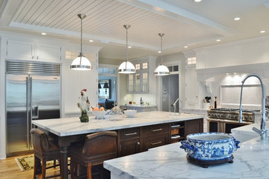 Eat-in kitchen - large traditional u-shaped light wood floor eat-in kitchen idea in DC Metro with shaker cabinets, white cabinets, marble countertops, white backsplash, subway tile backsplash, stainless steel appliances and an island