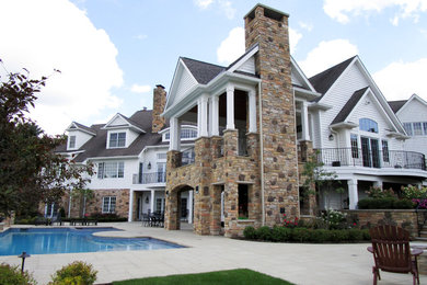 Mid-sized transitional backyard stone patio photo in Cleveland with a roof extension
