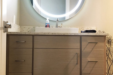 Inspiration for a mid-sized modern powder room remodel in Denver with flat-panel cabinets and quartz countertops