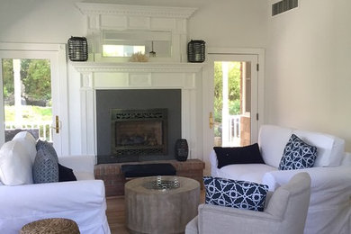 Example of a mid-sized transitional formal and open concept light wood floor living room design in New York with white walls, a standard fireplace, a metal fireplace and no tv