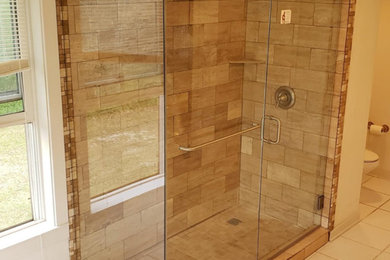 Mid-sized elegant master beige tile and travertine tile porcelain tile and white floor corner shower photo in New Orleans with white walls and a hinged shower door