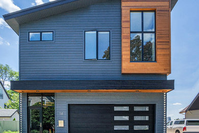 Example of a huge transitional gray two-story mixed siding house exterior design in Grand Rapids with a shingle roof and a shed roof
