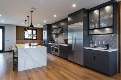 Mid-sized minimalist light wood floor kitchen photo in Cleveland with an undermount sink, flat-panel cabinets, gray cabinets, quartz countertops, gray backsplash, ceramic backsplash, stainless steel appliances and white countertops