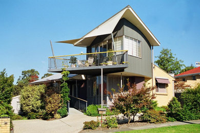 This is an example of a large contemporary two-storey multi-coloured house exterior in Melbourne with mixed siding.