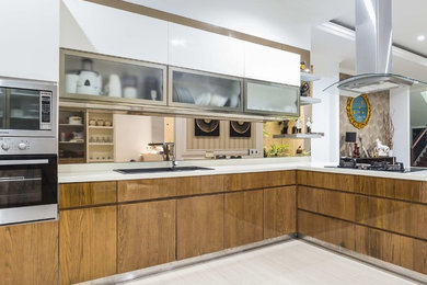 Mid-sized southwest l-shaped ceramic tile and beige floor kitchen photo in Other with a double-bowl sink, flat-panel cabinets, light wood cabinets, solid surface countertops, white backsplash, mirror backsplash, stainless steel appliances, an island and white countertops